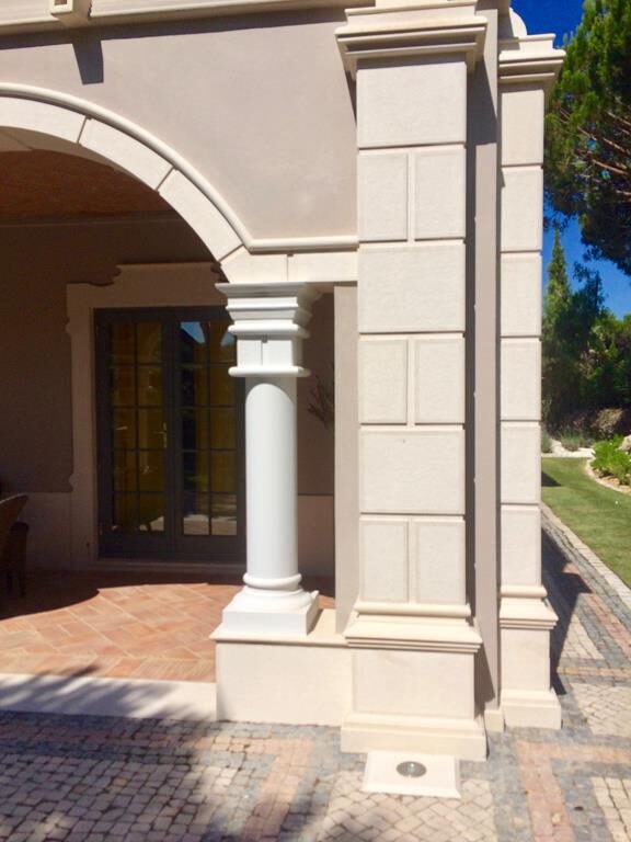 Coluna e arco em cantaria de pedra na entrada de uma moradia