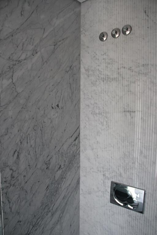 Detalhe de revestimento em mármore Carrara polido e estriado
